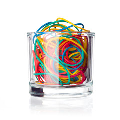 Colorful rubber bands in a glass isolated on white