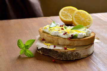 Lemon, basil, pink pepper, ricotta and honey bruschetta, copy space