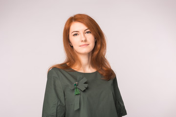 fashion, modeling and people concept - young red head woman standing over white background.