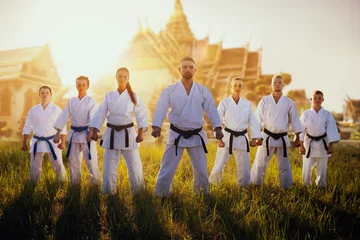 Crédence de cuisine en verre imprimé Arts martiaux Male and female karate group against temple