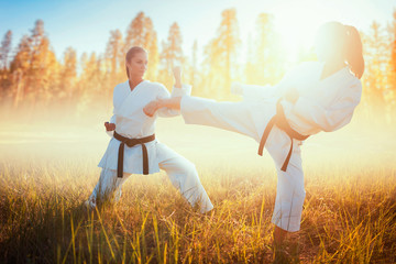 Two female karate in kimono fight in summer field © Nomad_Soul