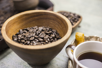 Coffee beans in a wooden Bowl on the wooden floor.