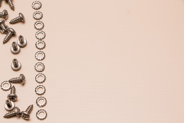 Self-tapping screw and washer (hardware) on a wooden background.