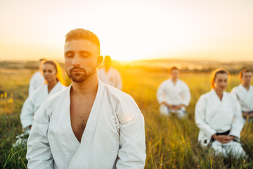 Karate master on outdoor training with his group