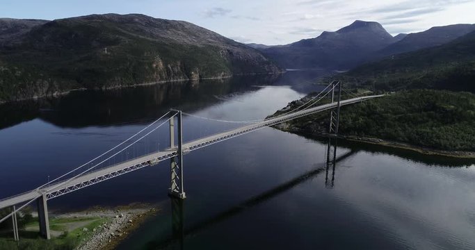 Aerial footage of bridge Rombaksbrua over Straumen bay of Ofotfjord. Cars on bridge and mountains in background. Narvik, Norway
