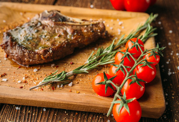 Grilled steak on the bone and tomatoes on a branch