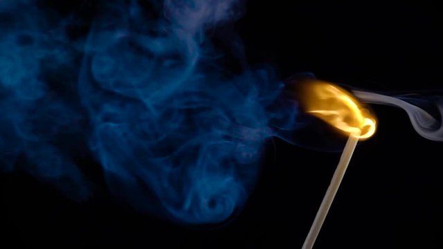 Burning match on a black background in slow motion