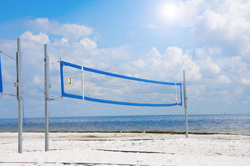 Empty volleyball court on a sandy beach at the waters edge shoreline on a beautiful sunny day