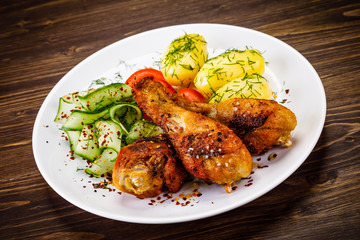 Grilled chicken drumsticks with boiled potatoes and vegetables