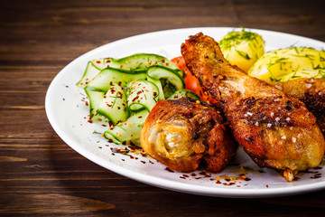 Grilled chicken drumsticks with boiled potatoes and vegetables