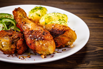 Grilled chicken drumsticks with boiled potatoes and vegetables