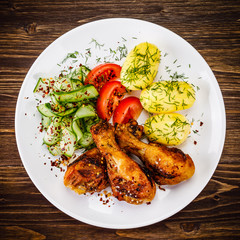 Grilled chicken drumsticks with boiled potatoes and vegetables