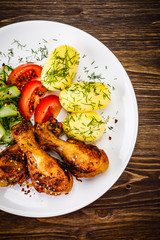 Grilled chicken drumsticks with boiled potatoes and vegetables