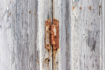 Detail of rusted wooden door painted in white