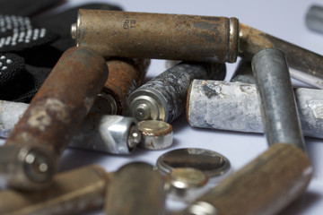 Used finger-wound batteries covered with corrosion. Next working gloves. Recycling.