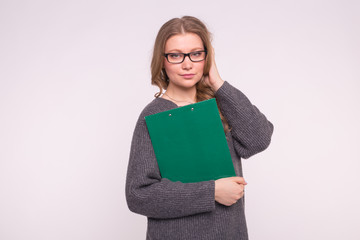Education, student and people concept - attractive woman over white background dressed in grey sweater hold paper folder