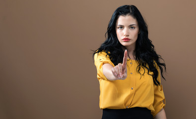 Young woman pointing at something on a solid background