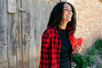 Fototapeta premium Beautiful young woman holding a red heart