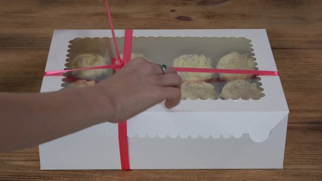 Girl child retrieves capcake from the box. Fragrant, vanilla capcake with berry filling and honey cream cheese, close up