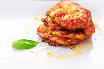 Parmigiana di melanzane. Traditional Italian dish: Baked eggplants with Parmesan cheese, decorated...
