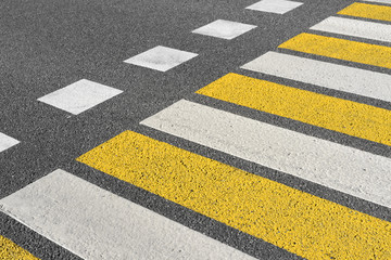Asphalt road crosswalk with marking lines white and yellow stripes. Road marking pattern.