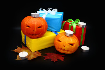 pumpkin, candles and gifts on a dark background