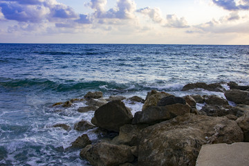 Landscape of the sundown in sea water amongst rocky beach