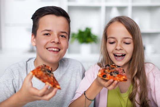 Happy teenagers eating pizza