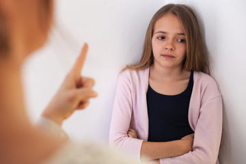 Woman lecturing her bored teenager daughter - pointing with finger