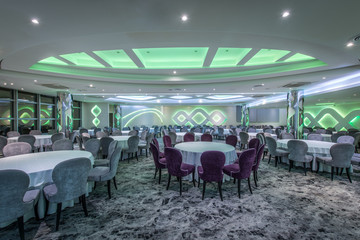 Setting tables and green lights ceiling in party hall