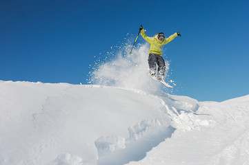Naklejka na ściany i meble Active skier in yellow sportswear riding down the slope in Georgia, Gudauri