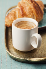 Breakfast setting with coffee and croissant