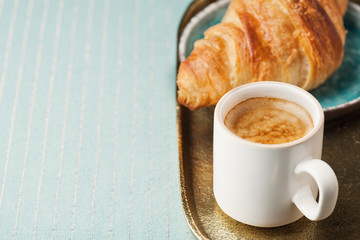 Breakfast setting with coffee and croissant