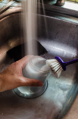 The hand of a man washing a glass of glass