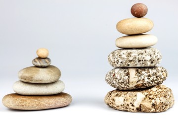Fototapeta na wymiar Pyramid of pebbles on a white background. Stones on the table. Wellness concept. Sea stones.