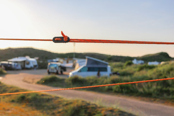 Orange guy rope and black adjuster holding a tent steady in its place. Firm fixation with caravans,...