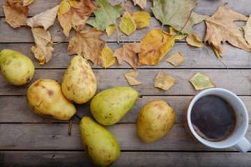 Coffee, pears and autumn leaves on a rustic wooden table 