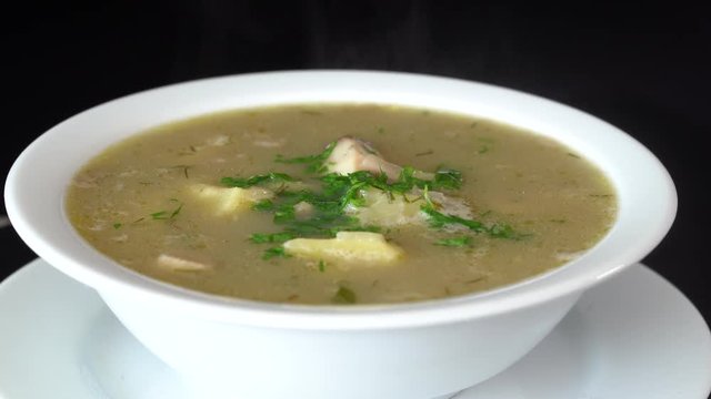 Vegetable soup with mushrooms and potatoes. Healthy food, mushrooms soup in white plate, close up, rotates