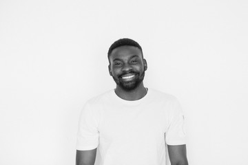 Single handsome muscular Black man with beard, folded arms and cheerful expression. black and white portrait