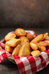 Wooden Bowl Lined with Red and White Checked Napkin Full of Homemade Cornbread Sticks, Muffins, and Slices