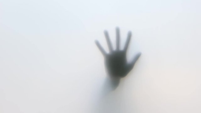 Close-Up of human hand on glass