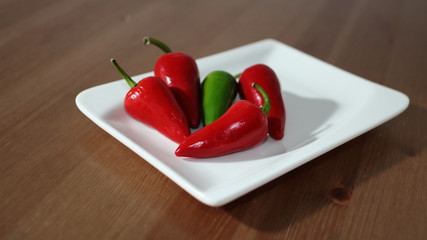 rote und grüner Chili auf weißem Teller