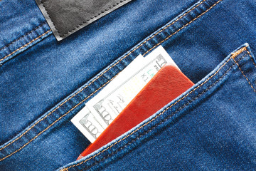 Money cash currency in blue jeans back pocket with notebook