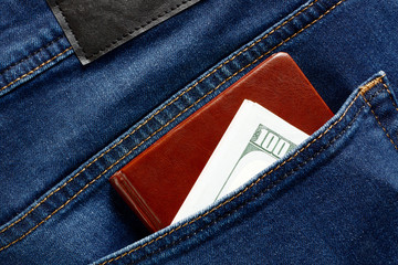 Money cash currency in blue jeans back pocket with notebook