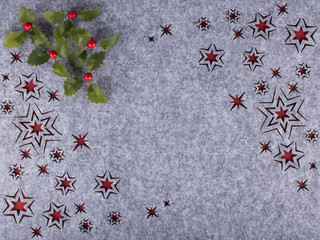 Decorative holly branches on grey background with stars