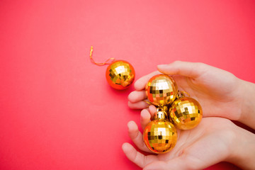 little yellow fur-tree toy in a female hand on a red background