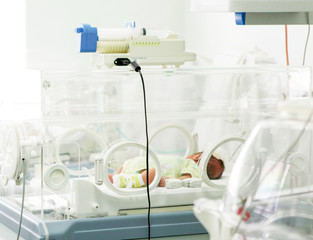 Fototapeta na wymiar Newborn baby in hospital incubator.