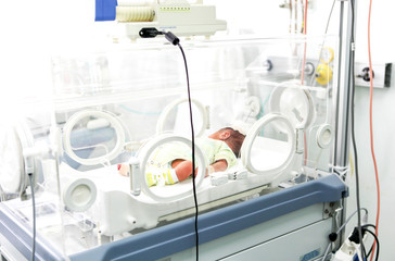 Fototapeta na wymiar Newborn baby in hospital incubator.