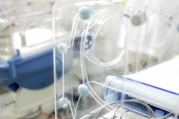 Newborn baby in hospital incubator.