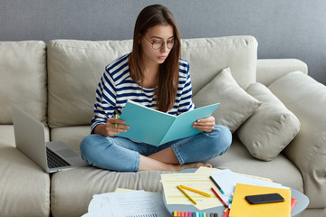 Young freelancer does ditance job at home, studies literature, learns foreign language in internet,...